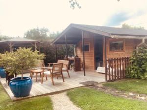 a wooden deck with a table and a house at Chalet La Romance in Prouilly