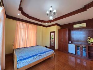 a bedroom with a bed and a chandelier at บ้านชมพู in Ban Nong Ban Kao