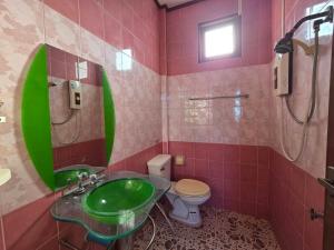 a bathroom with a green sink and a toilet at บ้านชมพู in Ban Nong Ban Kao