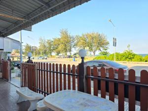 a fence with a table and a car in a parking lot at บ้านชมพู in Ban Nong Ban Kao