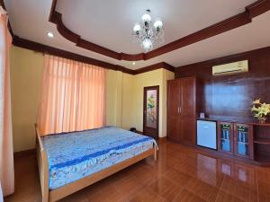 a bedroom with a bed and a chandelier at บ้านชมพู in Ban Nong Ban Kao