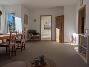a living room with a table and a dining room at Casa Tilly - Ferienhaus am Wald in Zwingenberg
