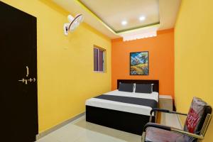 a bedroom with orange and yellow walls and a bed at Hotel O DS TANDOORI in Bokāro