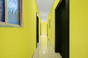 an empty hallway with yellow walls and doors at Hotel O DS TANDOORI in Bokāro