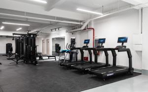 a gym with several treadmills and machines in a room at Neo-garden in Dali