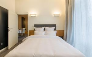 a bedroom with a large bed with white sheets at LETHESHOME Apartments in Porto
