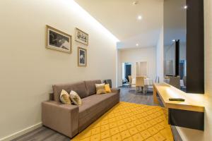 a living room with a couch and a yellow rug at LETHESHOME Apartments in Porto