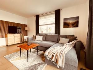 a living room with a couch and a table at Dünenhaus Lancken-Granitz in Lancken-Granitz