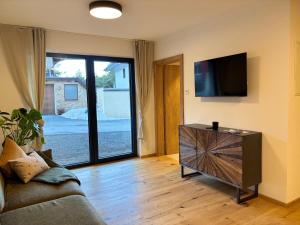 a living room with a couch and a flat screen tv at Apartment Leitner in Haiming