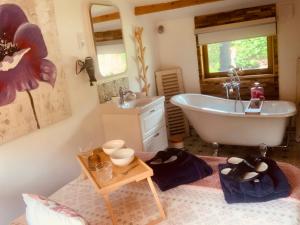 a bathroom with a tub and a sink at Chalet La Romance in Prouilly