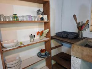 a kitchen with wooden shelves with bowls and dishes at Dario's Room1 in Kokrobite