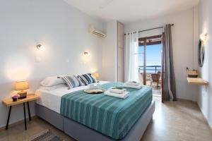 a bedroom with a bed with a view of the ocean at Hotel Barbati - Seaside Getaways with Pool in Barbati