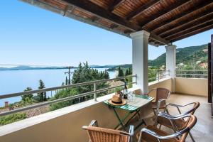 a balcony with a table and chairs and a view of the water at Hotel Barbati - Seaside Getaways with Pool in Barbati