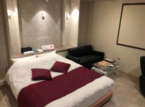 a hotel room with a large bed and a chair at ホテルアドレリゾート大人専用 in Sendai
