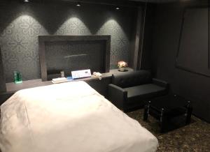 a bedroom with a bed and a chair and a mirror at ホテルアドレリゾート大人専用 in Sendai