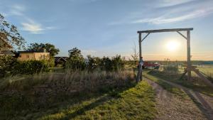a sun setting over a field with a dirt road at Ferienhof Löbejün in Löbejün