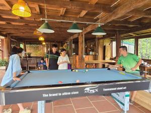 a group of people standing around a pool table at Ta Xua Ecolodge in Bắc Yên