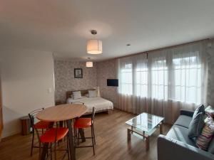 a living room with a table and a bed at Appart'Hotel Parc Johan in Chauffailles