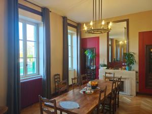 a dining room with a wooden table and chairs at Appart'Hotel Parc Johan in Chauffailles