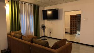 a living room with a couch and a flat screen tv at Wilpattu Leisure Villa in Pahala Maragahawewa