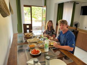 a man and woman sitting at a table with food at Wilpattu Leisure Villa in Pahala Maragahawewa