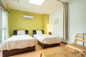 a bedroom with two beds and a chair at Fewdays Condominium608 in Sapporo +56 photos
