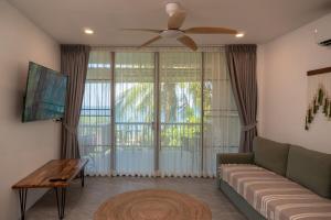 a living room with a couch and a ceiling fan at v26 Sunset Dreams - Seaview in Haad Yao in Haad Yao
