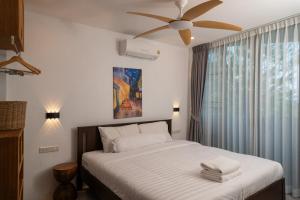 a bedroom with a bed with a ceiling fan and a window at v26 Sunset Dreams - Seaview in Haad Yao in Haad Yao +22 photos
