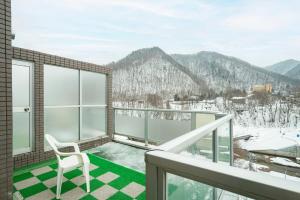 a balcony with a chair and a view of mountains at Fewdays Condominium608 in Sapporo