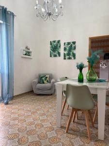 a dining room with a white table and chairs at Sweet home Angi in Marsala
