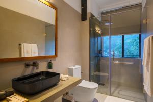 a bathroom with a sink and a glass shower at Te Dalu Resort & Spa - A Luxury Sanctuary in Ella in Ella +41 photos