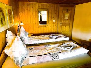 two beds in a room with wooden walls at BnB Haus Itten in Hondrich