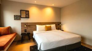 a bedroom with a large bed and a couch at Beehive Boutique Hotel Phuket in Phuket +42 photos