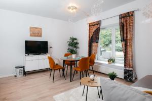 a living room with a table and chairs and a tv at Wonder Mandragora Mátrafüred in Gyöngyös