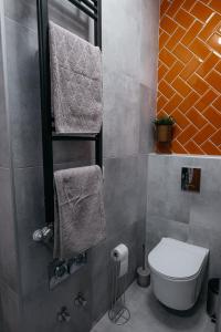 a bathroom with a toilet and towels in it at Wonder Mandragora Mátrafüred in Gyöngyös +6 photos