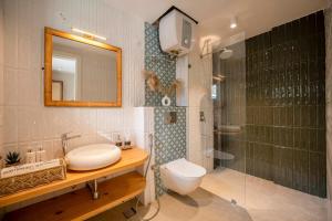 a bathroom with a sink and a toilet and a shower at Staymaster Solintra - Serviced Apartment - Pool in Nerul +49 photos