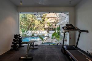 a gym with a view of a swimming pool at Staymaster Solintra - Serviced Apartment - Pool in Nerul