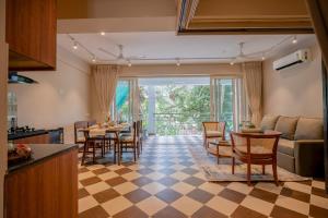a kitchen and living room with a table and chairs at Staymaster Solintra - Serviced Apartment - Pool in Nerul