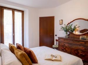 a bedroom with a bed with a book and glasses on it at Casa Riale 4 in Stresa