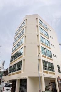 a white building with a street light in front of it at Homix Hotel in Singapore