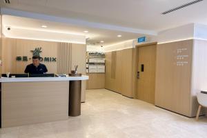 a man sitting at a counter in a lobby at Homix Hotel in Singapore