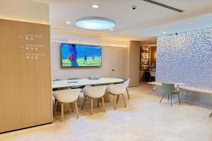 a conference room with a table and chairs and a screen at Homix Hotel in Singapore