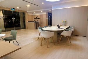 a room with a table and chairs with a laptop on it at Homix Hotel in Singapore