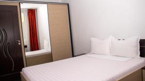 a bedroom with a white bed and a mirror at APARTAMENt ULTRACENTRAL in Tulcea