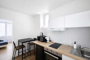 a kitchen with white cabinets and a counter top at Le Cocon d'Ezy in Ézy-sur-Eure