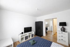 a bedroom with a bed and a desk with a television at Le Cocon d'Ezy in Ézy-sur-Eure