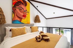 a bedroom with a bed with a painting on the wall at Palermo Suites by DH in Ubud