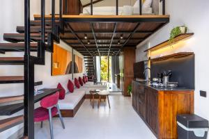 a living room with a staircase and red chairs at Palermo Suites by DH in Ubud