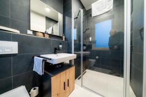 a bathroom with a sink and a glass shower at Pacmans Penthouse in Leipzig +7 photos