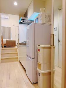 a kitchen with a white refrigerator and some boxes at Le Amo吉塚 in Fukuoka